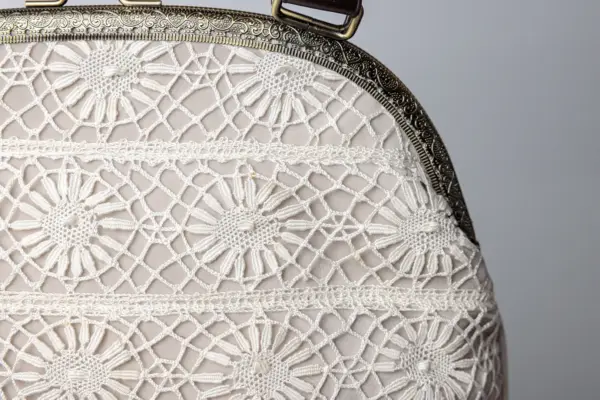 Bolso con encaje de bolillos floral.
